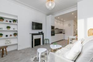 uma sala de estar com um sofá branco e uma lareira em MBA Splendide Appart - Le Raincy - Banlieue Paris em Villemomble