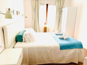 a bedroom with a large white bed with blue pillows at Hotel Miramar in Port de Soller