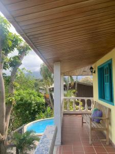 a porch with a wooden deck and a pool at Posada Villa Margarita in Los Naranjos