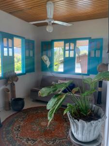 un soggiorno con divano e pianta in vaso di Posada Villa Margarita a Los Naranjos
