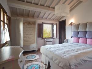 Un dormitorio con una gran cama blanca y una ventana en San Ruffino Apartments, en Lari