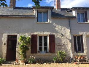 biały dom z brązowymi drzwiami i oknami w obiekcie Entre Loire et Sologne Maison d'hôtes w mieście Saint-Gervais-la-Forêt
