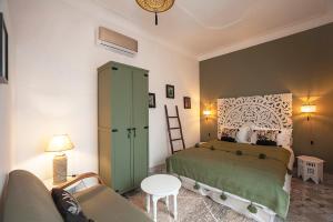 ein Schlafzimmer mit einem grünen Bett und einem Sofa in der Unterkunft RIAD JULILU PRIVATISE in Marrakesch
