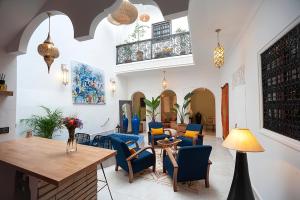 una sala da pranzo con sedie blu e tavolo di RIAD JULILU PRIVATISE a Marrakech