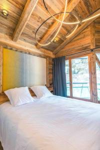 a bedroom with a white bed with a wooden ceiling at Top floor appartment, ski in ski out, superb view in La Daille