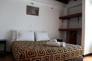 a bedroom with a bed with a stuffed animal on it at Mongui Plaza Hotel in Monguí