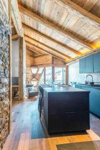 a kitchen with a black island in a room at Top floor appartment, ski in ski out, superb view in La Daille