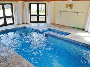 a swimming pool in a house with blue water at Penty Rosen in Pentewan