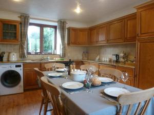 a kitchen with a table with chairs and a tableablish at Penty Rosen in Pentewan