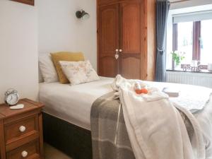 a bedroom with a bed with a blanket and a window at Penty Rosen in Pentewan