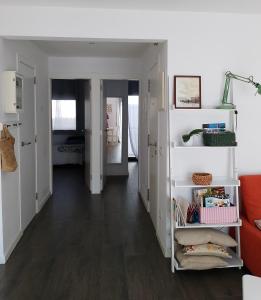 a living room with white walls and wood floors at Pis pràctic i agradable sobre la Marina Palamós in Palamós