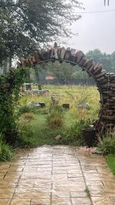 an archway in a field with cows in the grass at Soul Oasis Urban Retreat in Centurion +11 photos