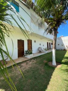 une maison avec un palmier en face dans l'établissement POUSADA CENÁRIO IDEAL, à Icapuí
