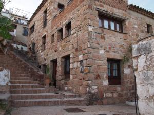 um antigo edifício de tijolos com escadas em frente em Posá la Cestería em Baños de la Encina