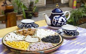 uma mesa com uma bandeja de diferentes tipos de alimentos em Mutara Bukhara em Bukhara