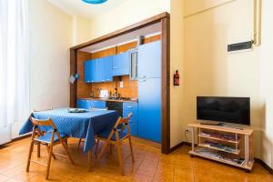une cuisine avec des placards bleus et une table avec des chaises dans l'établissement Apartment BOLOGNA City Center TRAIN STATION, à Bologne