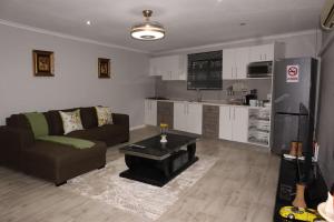 ein Wohnzimmer mit Couch und Küche in der Unterkunft Winter Hill Home - Familia in East London