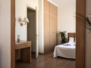 a bedroom with a bed and a dresser in it at Strada Marina Hotel in Zakynthos
