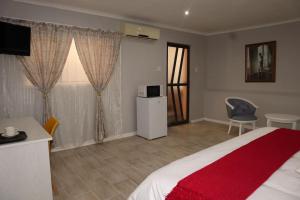 ein Schlafzimmer mit einem Bett, einem Tisch und einem Stuhl in der Unterkunft Winter Hill Home - Familia in East London