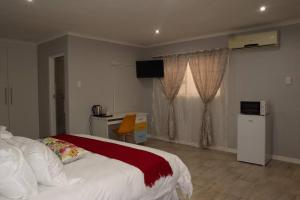 ein Schlafzimmer mit Bett, Schreibtisch und Fenster in der Unterkunft Winter Hill Home - Familia in East London + 45 Fotos