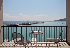 a table and chairs on a balcony with a harbor at Strada Marina Hotel in Zakynthos