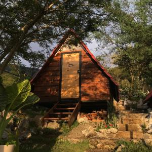 una pequeña cabaña de madera con una puerta. en Cabañas Yei Calli, en Ciudad Mendoza