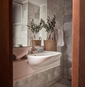 a bathroom with a sink and two potted plants at Strada Marina Hotel in Zakynthos