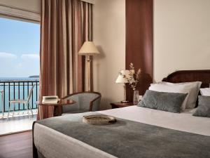 a hotel room with a bed and a balcony at Strada Marina Hotel in Zakynthos