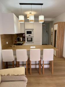 een keuken met een eettafel en witte stoelen bij Summer Breeze Tenerife, Palm-Mar in Palm-mar