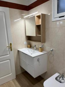 een badkamer met een witte wastafel en een spiegel bij Summer Breeze Tenerife, Palm-Mar in Palm-mar