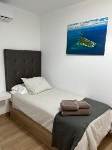 een slaapkamer met een bed met een schilderij aan de muur bij Summer Breeze Tenerife, Palm-Mar in Palm-mar