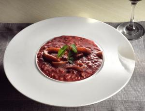 a white plate with a bowl of food on a table at Strada Marina Hotel in Zakynthos