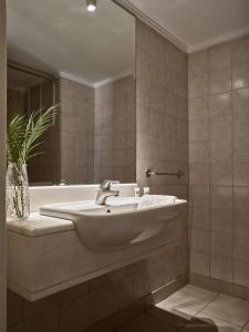 a bathroom with a sink and a bath tub at Strada Marina Hotel in Zakynthos