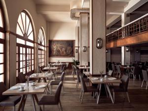 a restaurant with tables and chairs and windows at Strada Marina Hotel in Zakynthos
