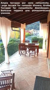 a patio with benches and tables with a sign on it at Confidence house in Gardone Riviera