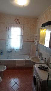 a large bathroom with a tub and a sink at Confidence house in Gardone Riviera