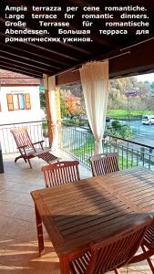einen Holztisch und Stühle auf einer Terrasse in der Unterkunft Confidence house in Gardone Riviera