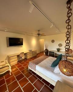 a bedroom with a bed and a flat screen tv at El Percal Hacienda Hotel in Montenegro