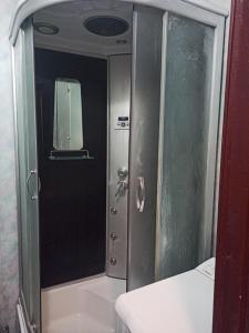 een douche met een glazen deur in de badkamer bij Апартаменти 15 хв від жд вокзалу in Lviv