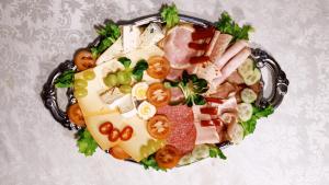 um prato de alimentos com carne e legumes sobre ele em Pension Ramona - Hotel Garni em Bad Soden-Salmünster