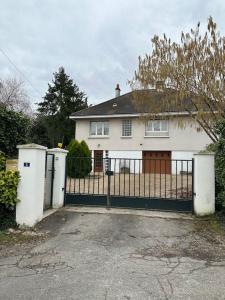 una casa blanca con una puerta y una valla en Gîte d'Esila en Saint-Aignan