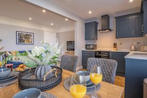a kitchen and dining room with a table with orange juice at luxury 2 bed apartment, sea view, near the beach. in Llandrillo-yn-Rhôs