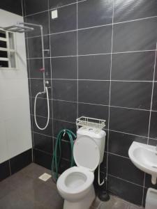 a bathroom with a shower and a toilet and a sink at Homestay Hafiy Manjung Lekir Sitiawan in Lekir