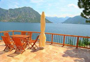 a table and chairs on a balcony with a view of a lake at Villa Strp in Risan