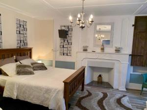 1 dormitorio con 1 cama grande y chimenea en The LightHouse Chambres à louer, en Châteaulin