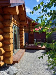 eine Blockhütte mit einer Veranda und einer Terrasse in der Unterkunft The Cabin in Twizel