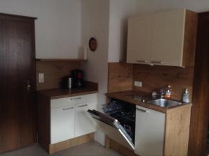 a small kitchen with a sink and a stove at Ferienwohnung Blumen Penz in Zell am Ziller +2 photos