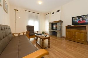 a living room with a couch and a tv at Hotel Apolo in Aínsa