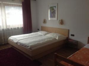 a bed in a bedroom with a window at Ferienwohnung Blumen Penz in Zell am Ziller