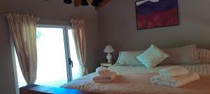 sypialnia z łóżkiem z ręcznikami w obiekcie Malva w mieście El Bolsón